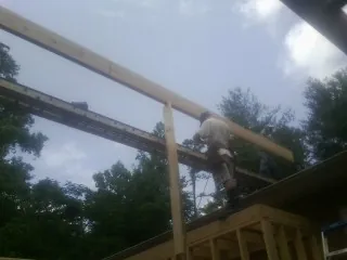 Carpenter setting a ridge beam over a new addition frame — Ice Dam Removal by Roofing Brothers in Greenwich